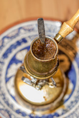 Brewing fresh Turkish coffee pot on portable stove.