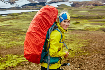 woman hiker on the trail in the Islandic mountains. Trek in National Park Landmannalaugar, Iceland