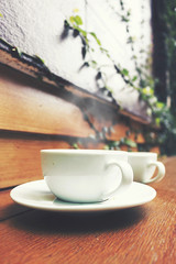 cup of hot coffee on table, over light and retro tone [blur and select focus background]