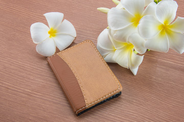 Notebook and Plumeria flower on wood background