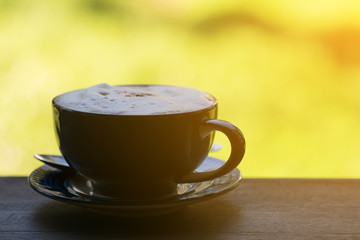 Coffee Cup on Wood Table In Morning with Blurred Background