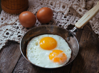 two eggs fried in a small pan in a retro style