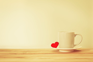 Coffee cup mug with red heart shape on wooden table , Romance