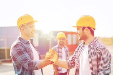 group of smiling builders in hardhats outdoors