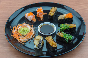Sushi Set and sushi rolls served on wood table.