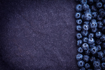  fresh picked blueberries on black stone background