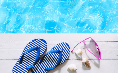 flip-flops and sunglasses on the swimming pool