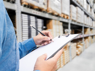 Man checking  list on clipboard in a warehouse