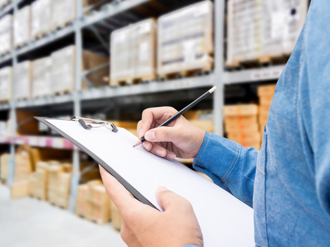 Man checking  list on clipboard in a warehouse