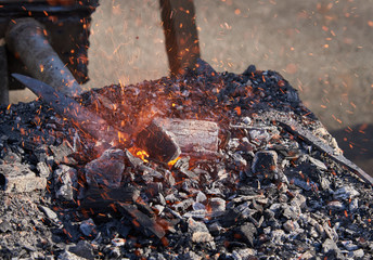 The heating of metal billets on hot coals