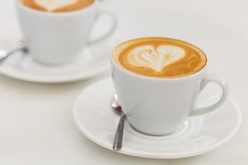 Cup of art latte or cappuccino coffee with retro filter effect