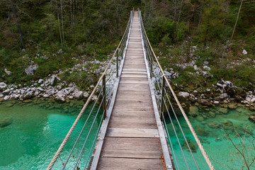 Wooden bridge the turquoise green Soca river in Slovenia