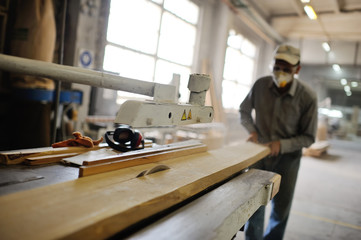 carpenter saws a board a circular saw