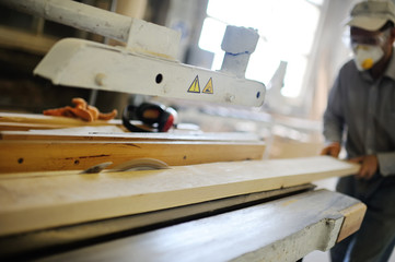 carpenter saws a board a circular saw