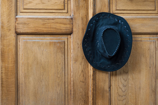 Black cowboy hat hanging on the door handle