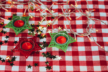 candle on red checkered tablecloths and garland