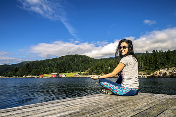 Fototapeta na wymiar Young woman enjoying the sunny day on the fjord, Norway