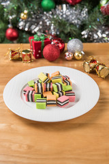 The sugar in the white bowl is on the wooden table and Christmas