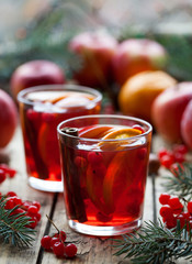 Winter hot sangria or mulled wine with apples, oranges, pomegranate and cinnamon.Christmas tree decorations. Close up.