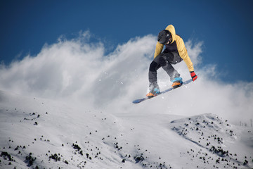 Flying snowboarder on mountains. Extreme sport.