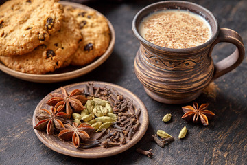 Masala pulled tea chai latte traditional hot Indian sweet milk spiced drink, ginger, nutmeg fresh spices blend, anise organic infusion healthy wellness beverage teatime ceremony in rustic clay cup