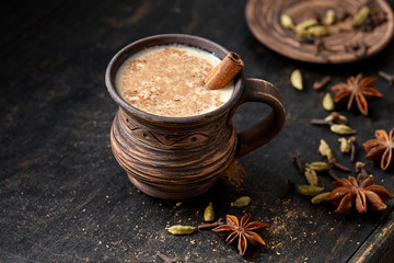 Masala pulled tea chai latte hot Indian sweet milk spiced drink, ginger, fresh spices and herbs...