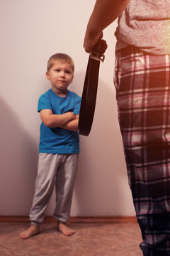 Mother holding belt to punish little son