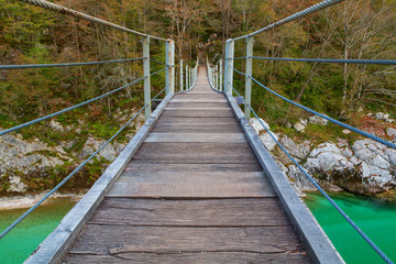 Wooden bridge the turquoise green Soca river in Slovenia