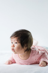 Fototapeta premium newborn baby girl in pink dress on white background