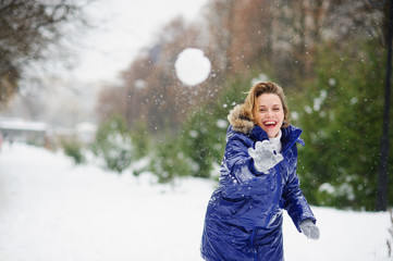 Charming girl throws snowballs.