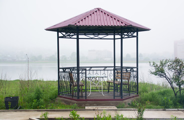 Public gazebo on a coast of lake.