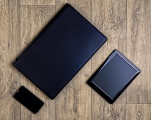 Gadgets on wooden background, top view, laptop, smartphone, tablet