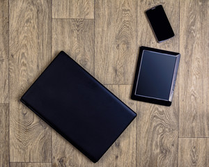Gadgets on wooden background, top view, laptop, smartphone, tablet