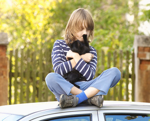 Boy Sitting Holding a Pet Kitten