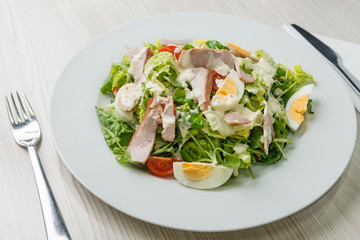 Nutritious vegetable salad with boiled egg slices and salmon