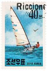 Fototapeta premium Sailing yacht in the sea on postage stamp