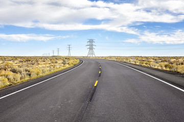 An empty rural highway with electric poles