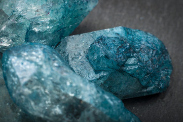 Closeup of a bunch of many blue rough uncut sapphire crystals