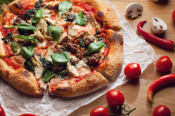 Fresh pizza with ingredients on wooden table