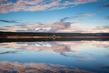 Fototapeta na wymiar Reflected Sky in Kielder Reservoir, in Kielder Water and Forest Park, Northumberland, which has the largest man made lake in Northern Europe. The reservoir sits in the North Tyne Valley