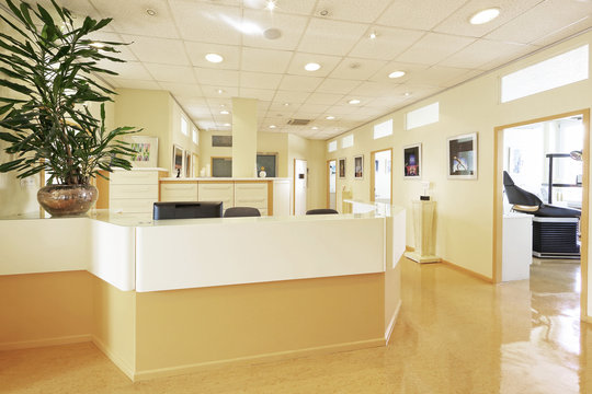 Empfangsbereich in einer Zahnarztpraxis mit Behandlungszimmer in Hintergrund