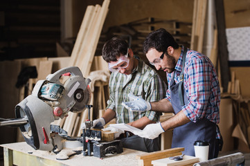 Inspector and carpenter discuss the process of making wood products for furniture