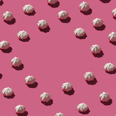 Pattern made of sweet meringues on pink background.