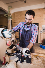Carpenter Using Circular Saw for wood at his workshop