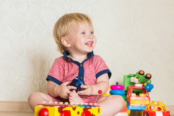 Portrait of a baby boy on the floor with toys