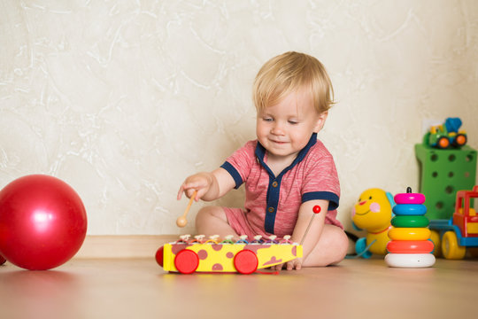 Portrait of a baby boy on the floor with toys