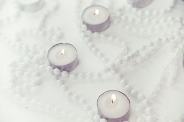 small candles surrounded by white beads