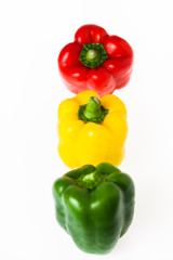 poivrons rouge verts et jaunes alignés sur fond blanc