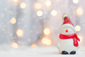 Christmas and new year background - snowman figurine against christmas lights, with copy space