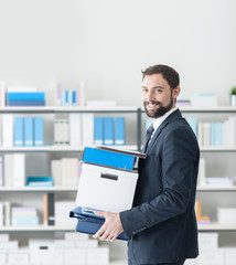 Businessman carrying a box and office folders